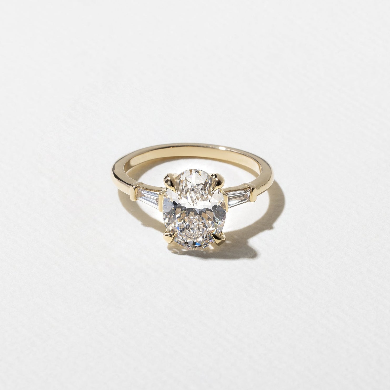 2.05 carat oval cut lab grown diamond three stone ring with tapered baguettes